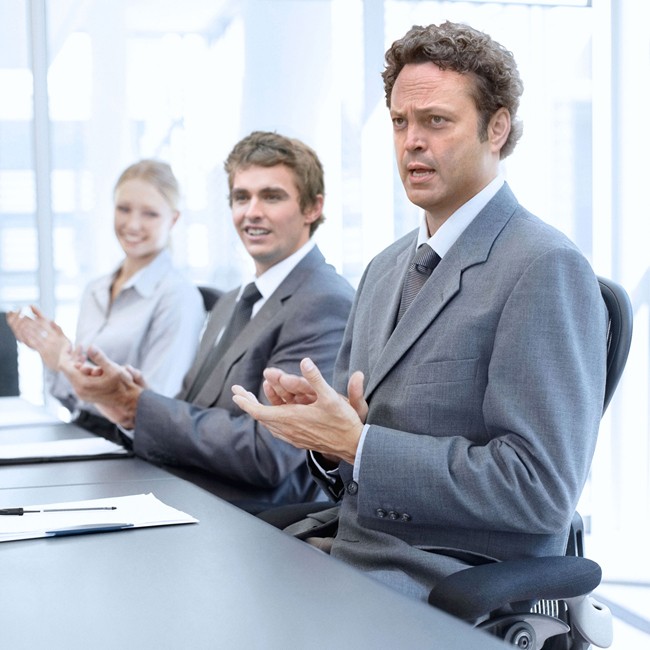 Successful applauding executives sitting at the table