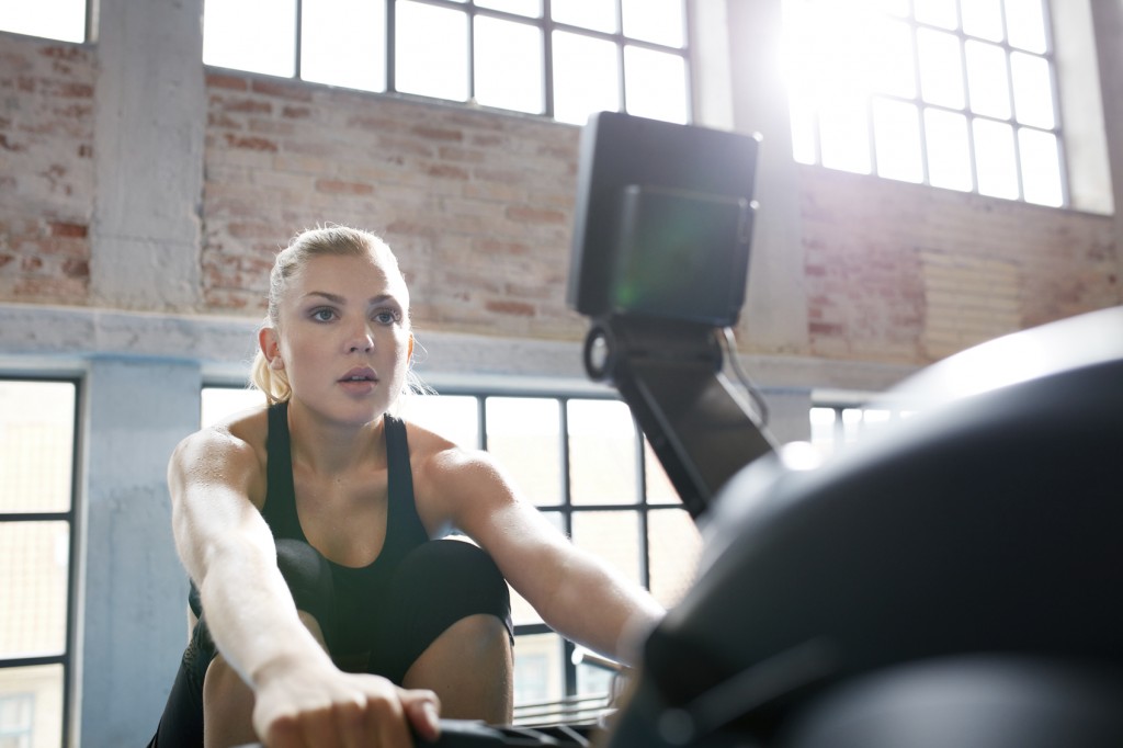 Female working out on a rowing machine at the gym