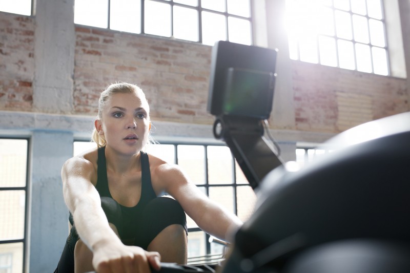 Female working out on a rowing machine at the gym