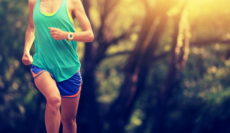 Runner athlete running on forest trail.