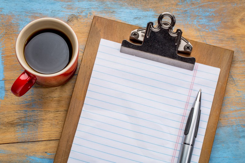 blank paper on clipboard and coffee