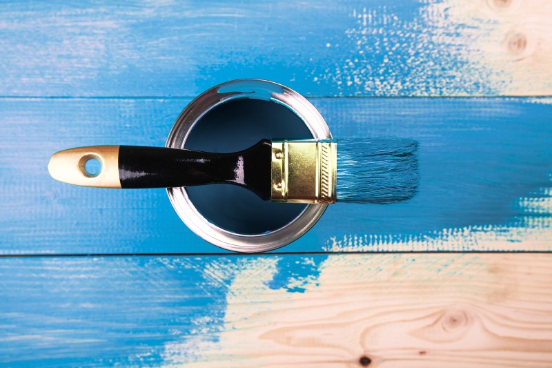 Painting a wooden shelf using paintbrush