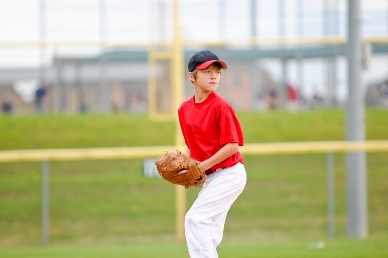 Youth baseball pitcher in red jersey