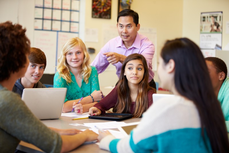 High School Students With Teacher In Class Using Laptops