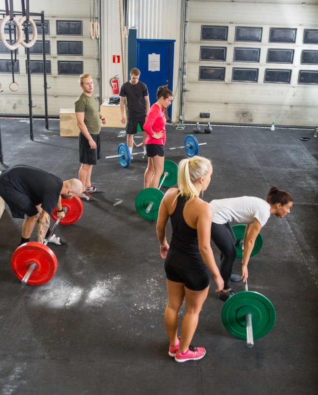 35442239 - trainers with athletes lifting barbells