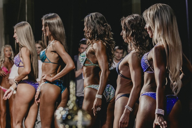 Blonde and brunette in bikini standing sideways on the stage