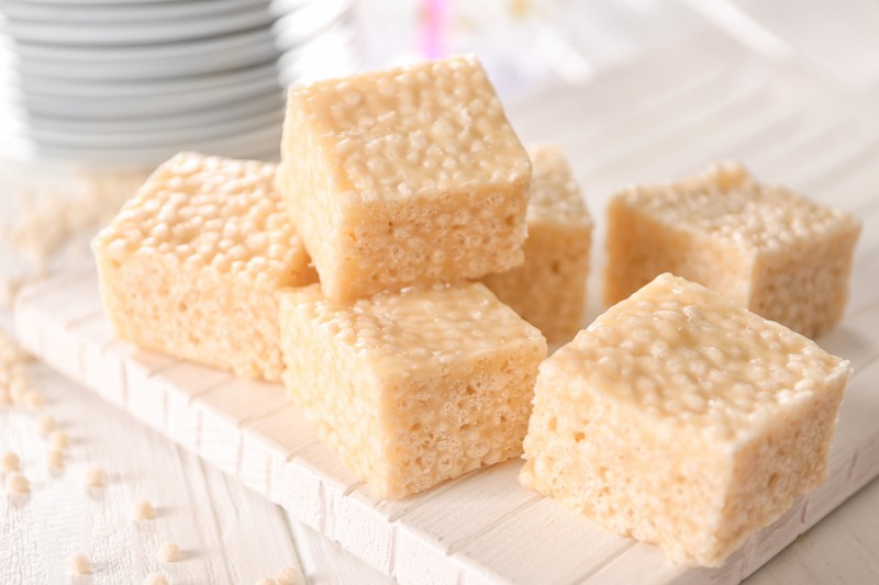 Delicious pieces of rice crispy treats on cutting board