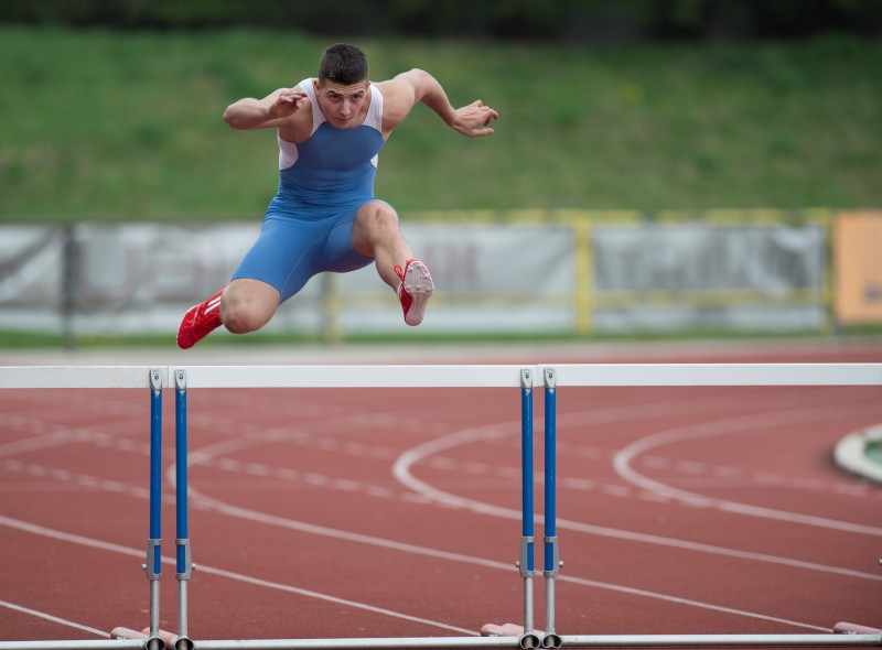 12985851 - professional sprinter jumping over a hurdle