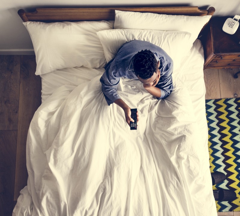 Man in bed watching a TV