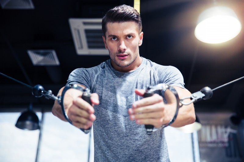 Man workout on fitness machine in gym