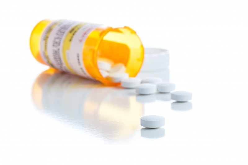 Non-Proprietary Medicine Prescription Bottle and Spilled Pills Isolated on a White Background.