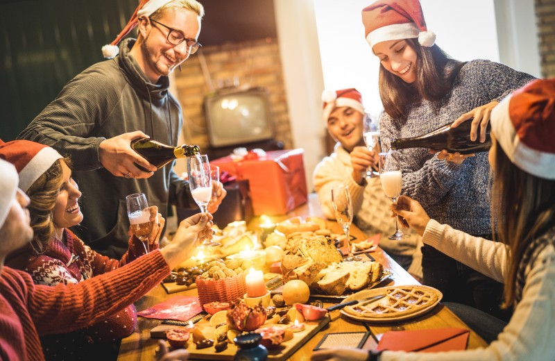 Friends group with santa hats celebrating Christmas with champag