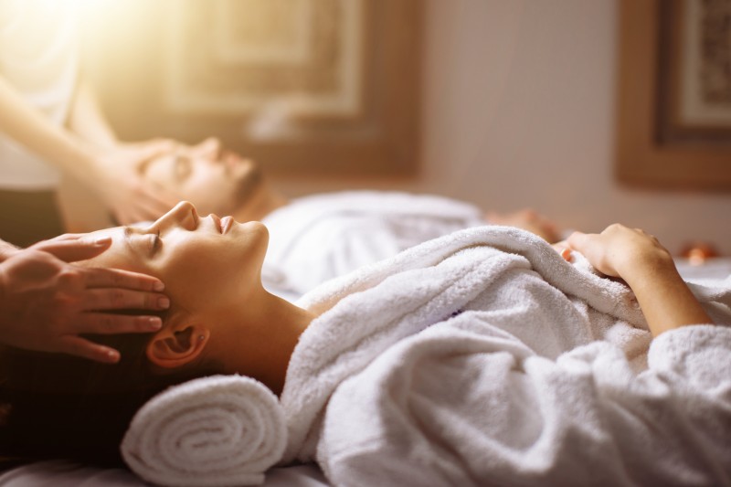 Young couple receiving head massage at beauty spa